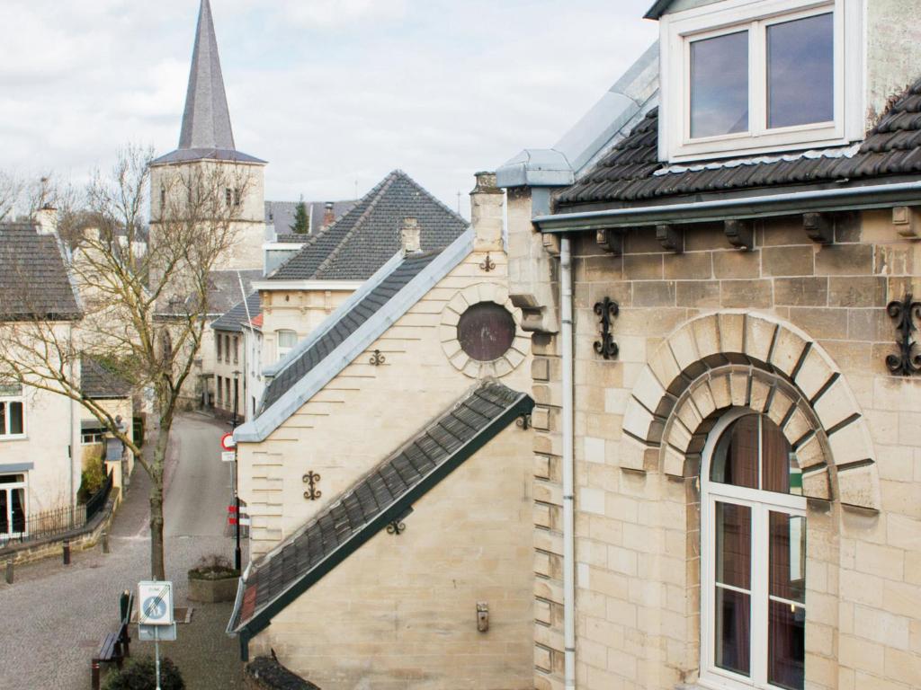 een uitzicht op een gebouw met een raam en een kerk bij Quiet holiday home in Valkenburg in Valkenburg