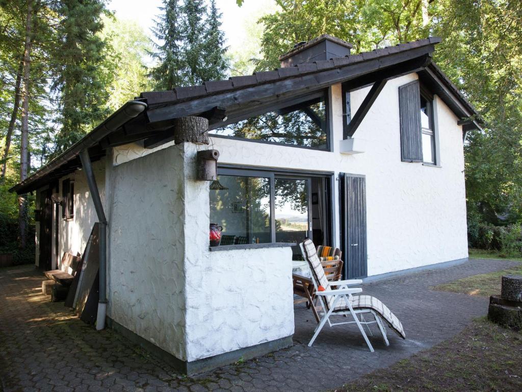 a small white house with a roof on a patio at Holiday home in Lissendorfer with terrace in Lissendorf