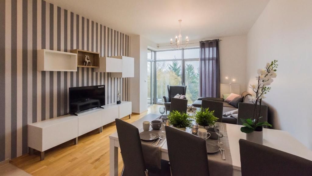 ein Wohnzimmer mit einem Tisch und einem Esszimmer in der Unterkunft VacationClub - Diune Apartment 50 in Kołobrzeg