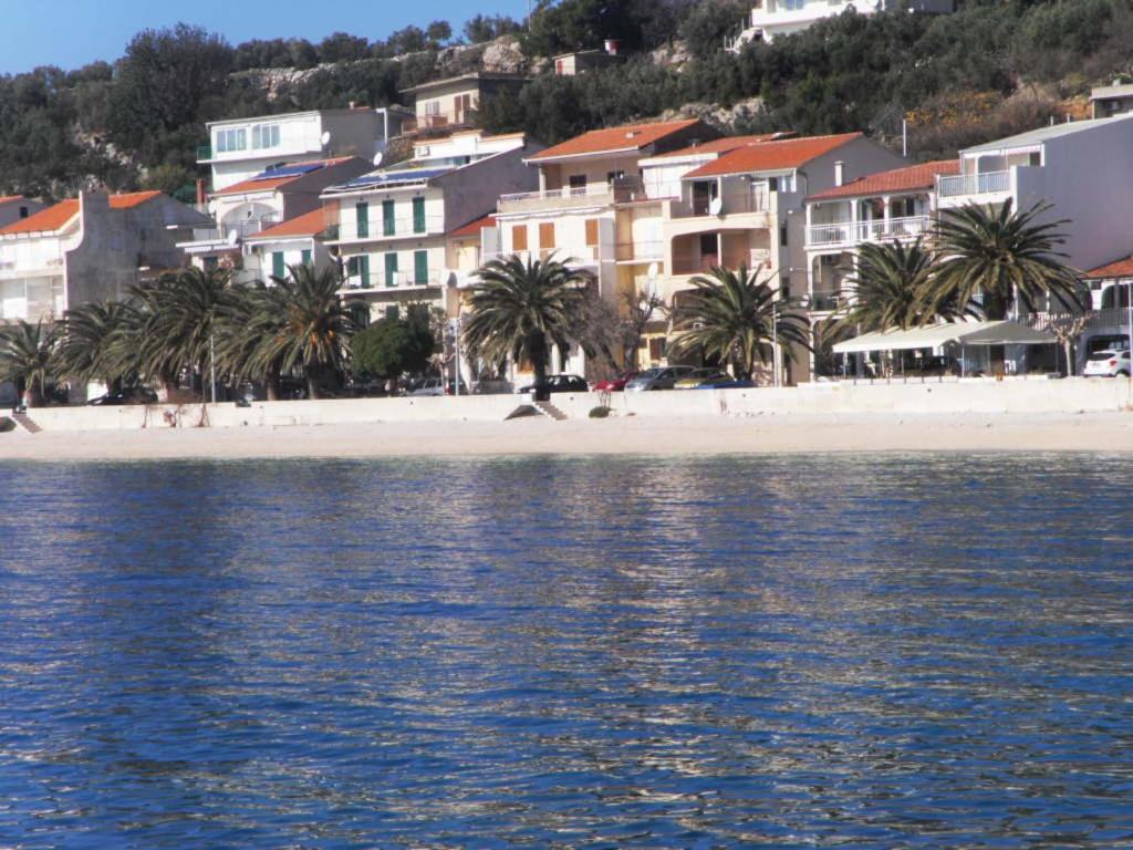 uma vista para uma praia com palmeiras e edifícios em Apartment Marjana em Podgora