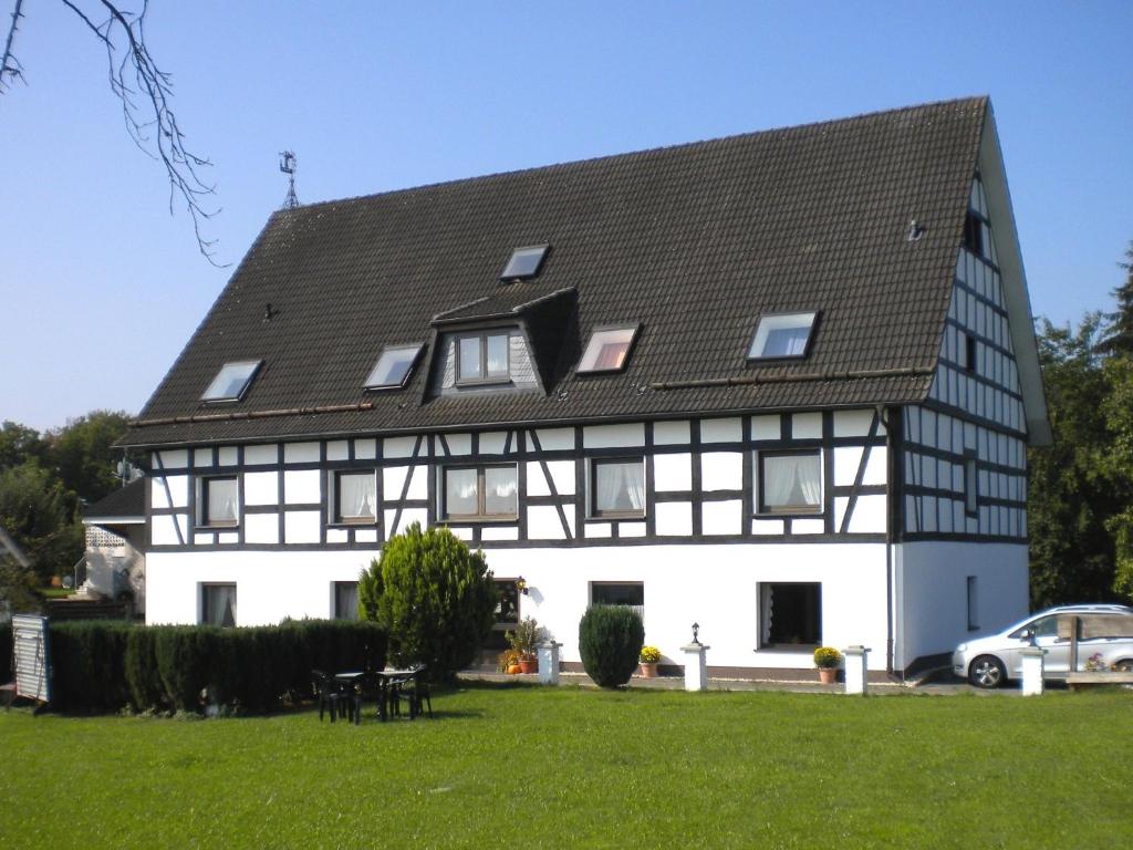 a large white house with a black roof at Apartment with panoramic views in Attendorn