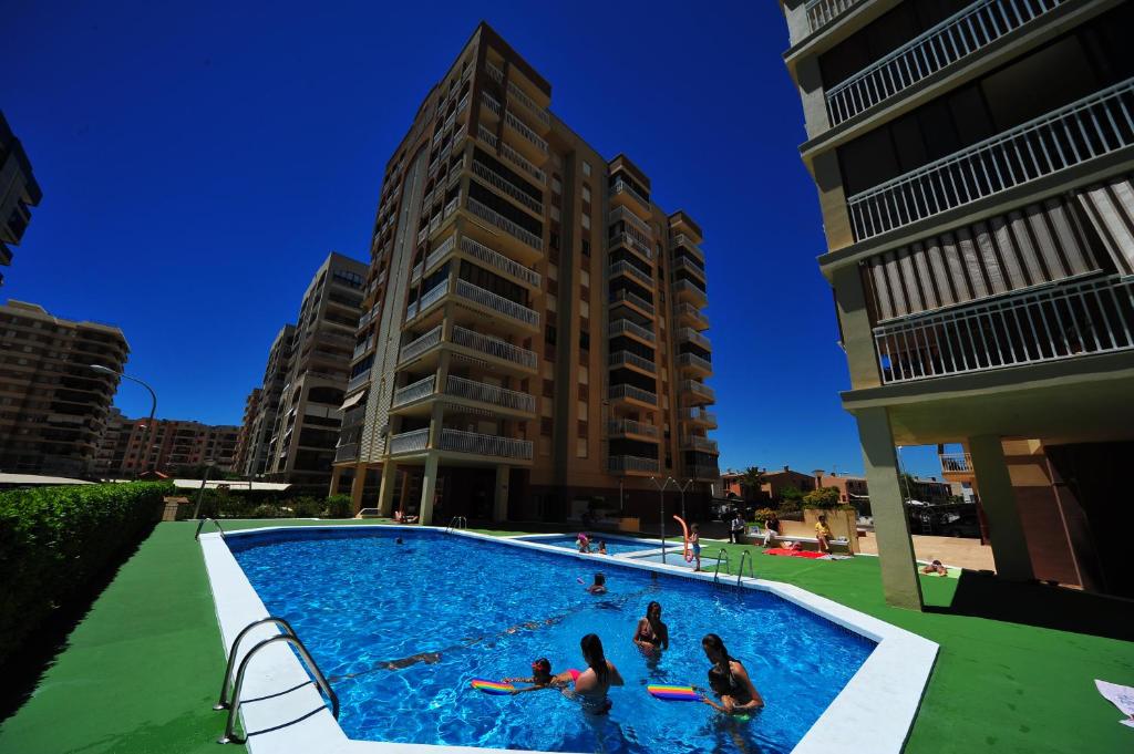 a group of people in a swimming pool with buildings at Apartamento Olimpo Orange Costa in Benicàssim
