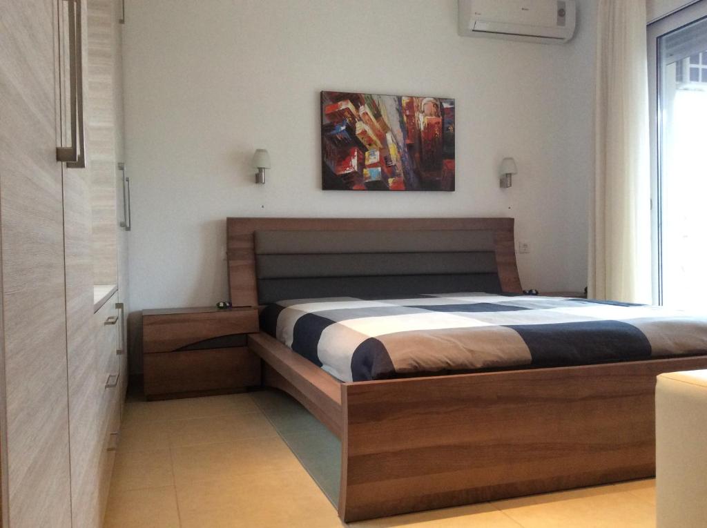 a bedroom with a bed and a painting on the wall at Mariza's Guest House in Skiathos