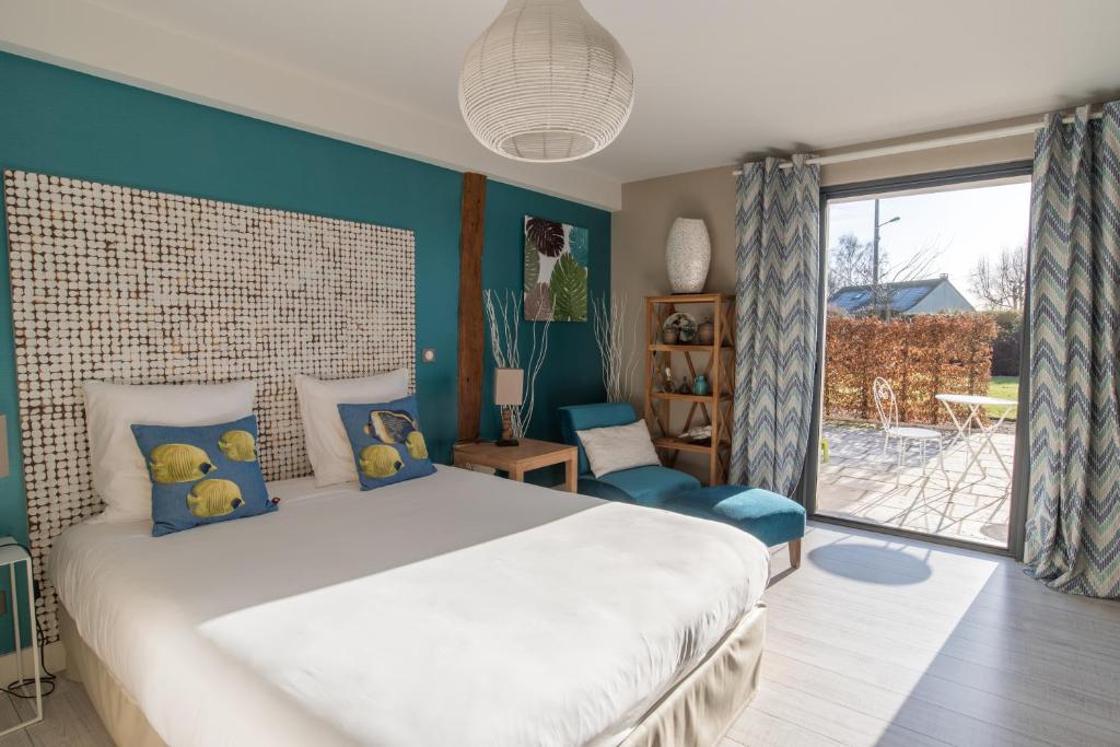 a bedroom with a large bed with blue walls at Aux 5 Sens in Tillé