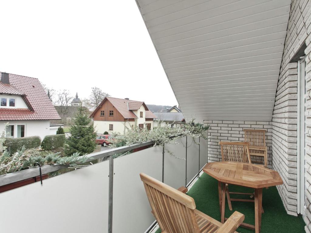 a patio with a table and chairs on a balcony at Apartment in Nieheim on the edge of the forest in Sandebeck