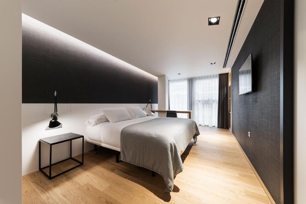 1 dormitorio con cama blanca y pared negra en Hotel U Viveiro, en Viveiro