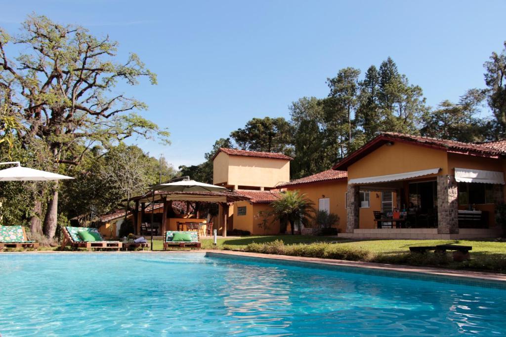 a house with a swimming pool in front of a house at Hospedagem Fazenda Nova América in Brotas