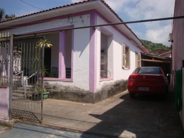 um carro vermelho estacionado em frente a uma casa em Suíte Aconchegante em Caraguatatuba