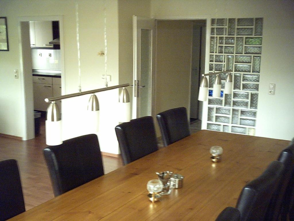 ゲロルシュタインにあるCharming Apartment in Gerolstein Germany with Large Verandahのダイニングルーム(木製テーブル、椅子付)