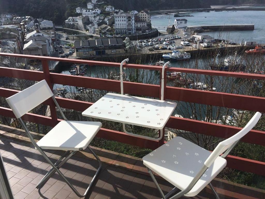 2 sillas y una mesa en un balcón con puerto en Apartamento Bellavista, en Luarca