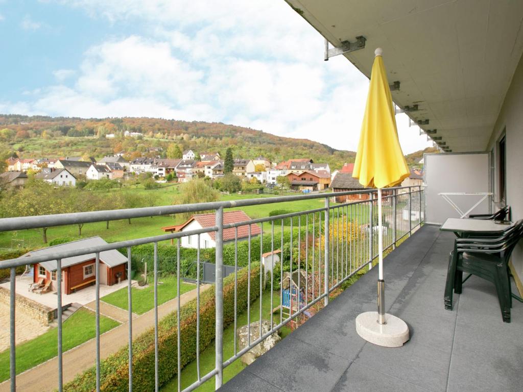 ボレンドルフにあるForest view Apartment in Bollendorf with Large Balconyの黄色い傘とデスク付きのバルコニー