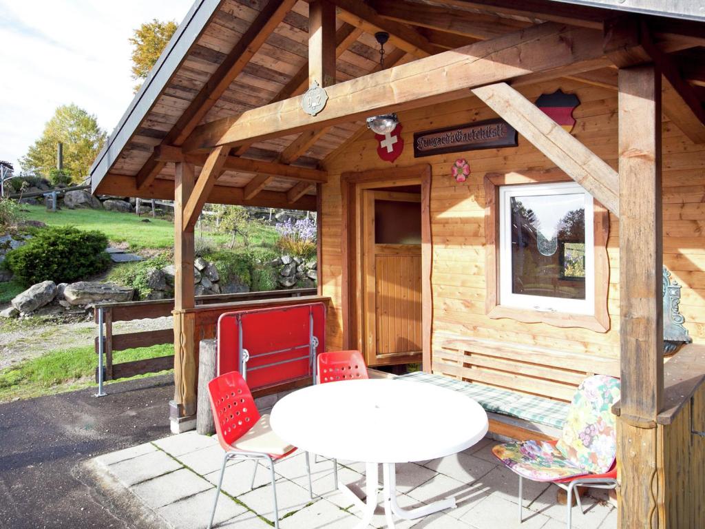 uma pequena cabina com uma mesa branca e cadeiras em Komfortable Ferienwohnung im Schwarzwald em Urberg