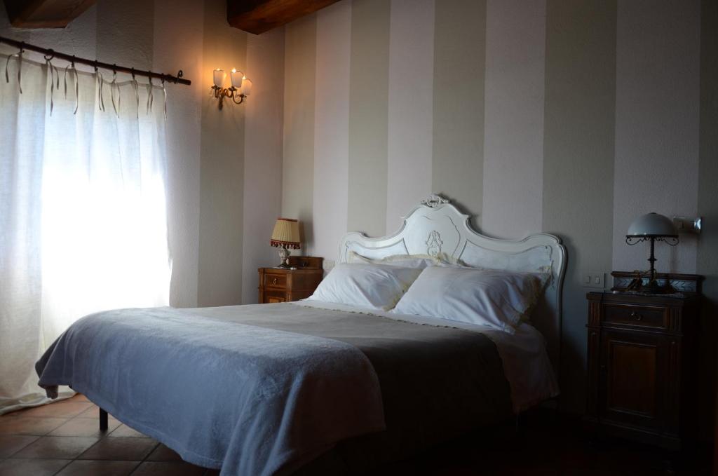 sypialnia z białym łóżkiem i oknem w obiekcie Il Borghetto di Carra w mieście Talla