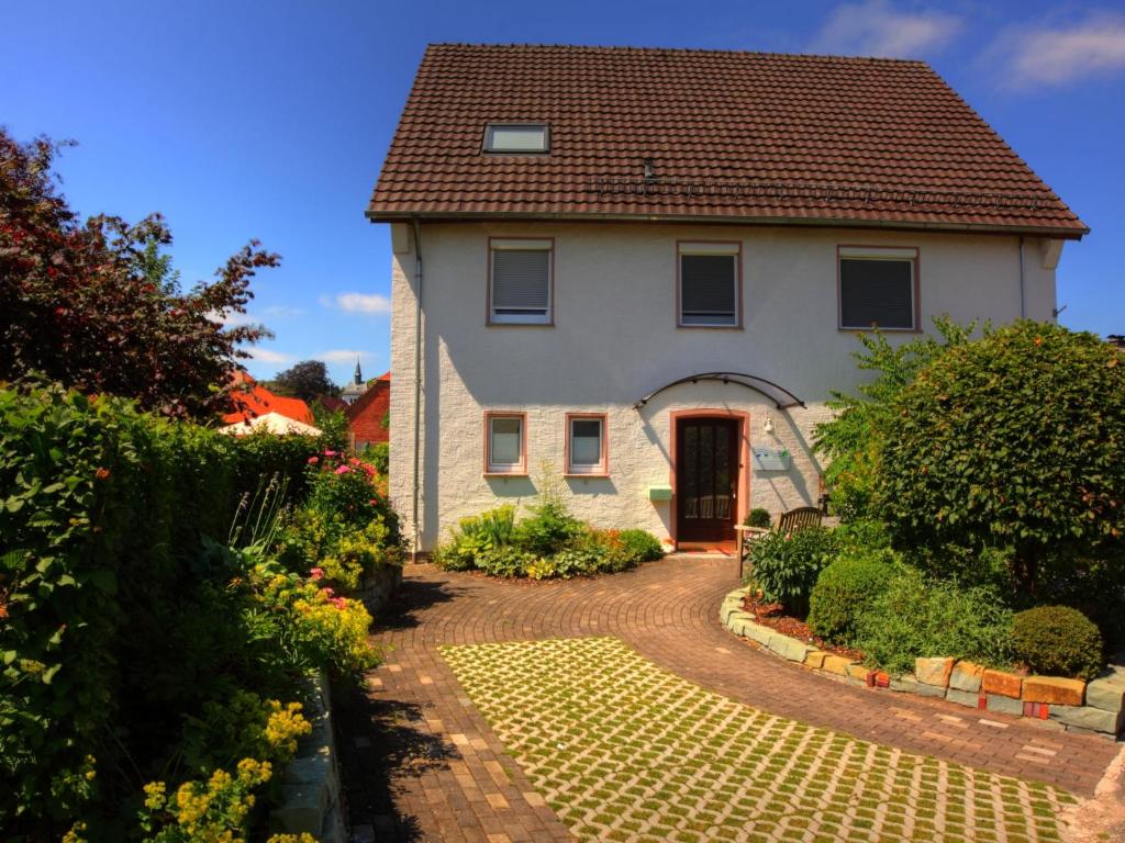 a white house with a red door and a driveway at Apartment with sauna in Merlsheim