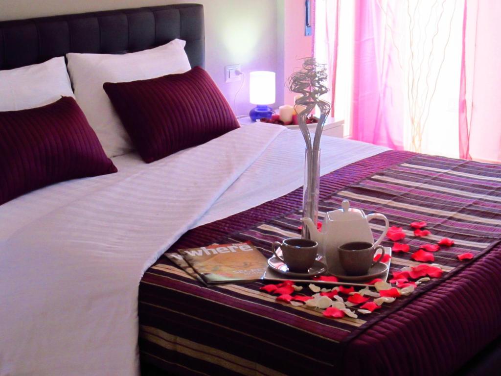 a bed with a tray with flowers and cups on it at Sleep And Fly Rome Airport in Fiumicino