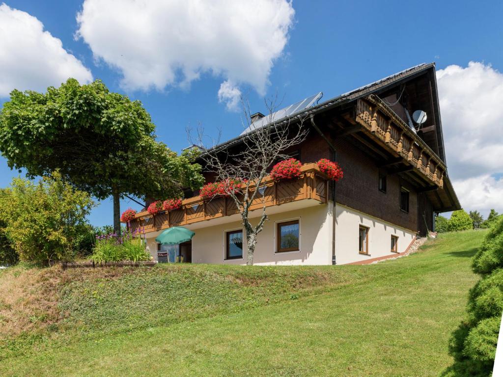 a house on top of a hill with red flowers at Quiet apartment in Neukirch with private terrace in Furtwangen