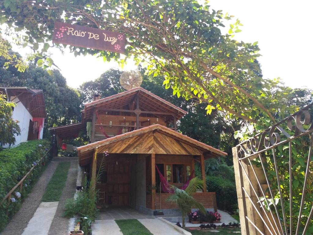 a small wooden building with a sign on it at Chale Raio De Luz in Visconde De Maua