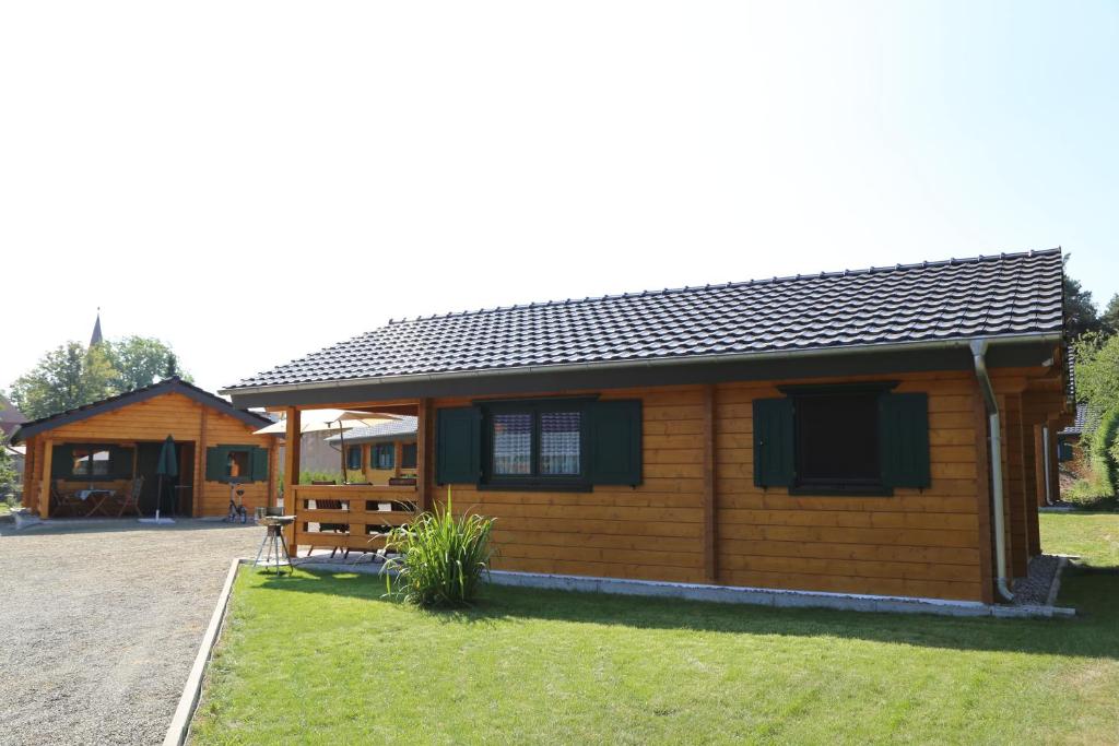 eine große Holzhütte mit einer Veranda im Hof in der Unterkunft Ferienpark Seeblick in Großkoschen