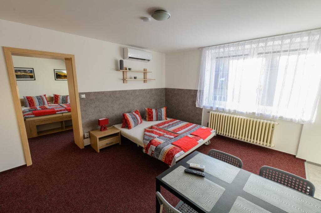 Pokój z łóżkiem, stołem i lustrem w obiekcie Apartmány Vilma w mieście Lednice