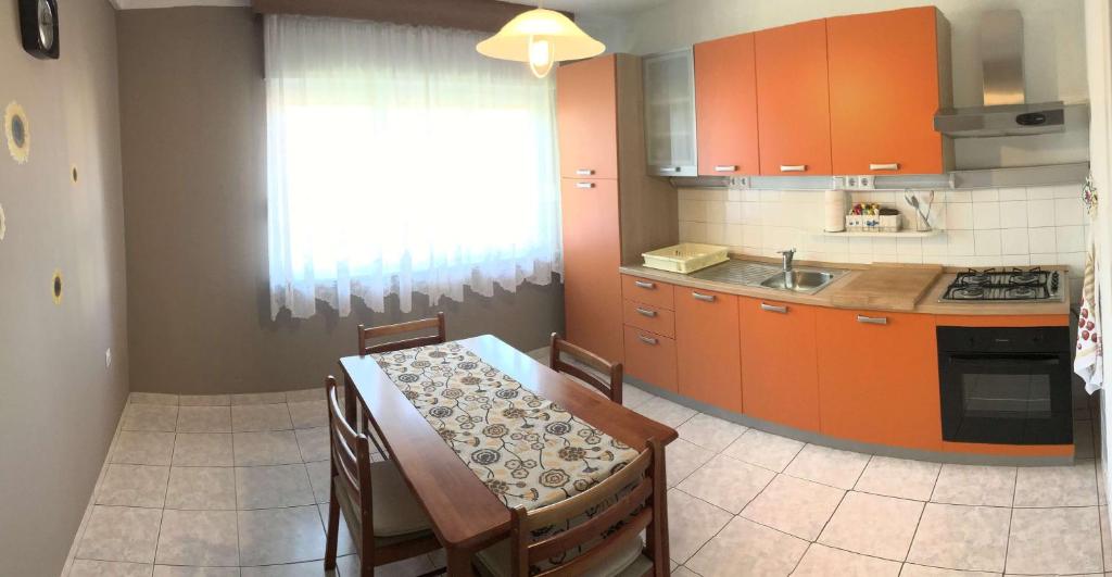 a kitchen with orange cabinets and a table with chairs at Luka in Pula