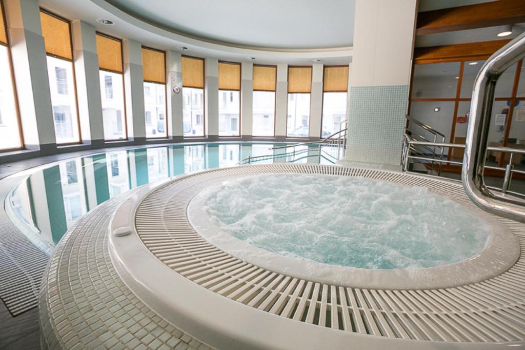 uma grande piscina com uma banheira de hidromassagem num edifício em VIP Apartamenty Stara Polana 2 em Zakopane