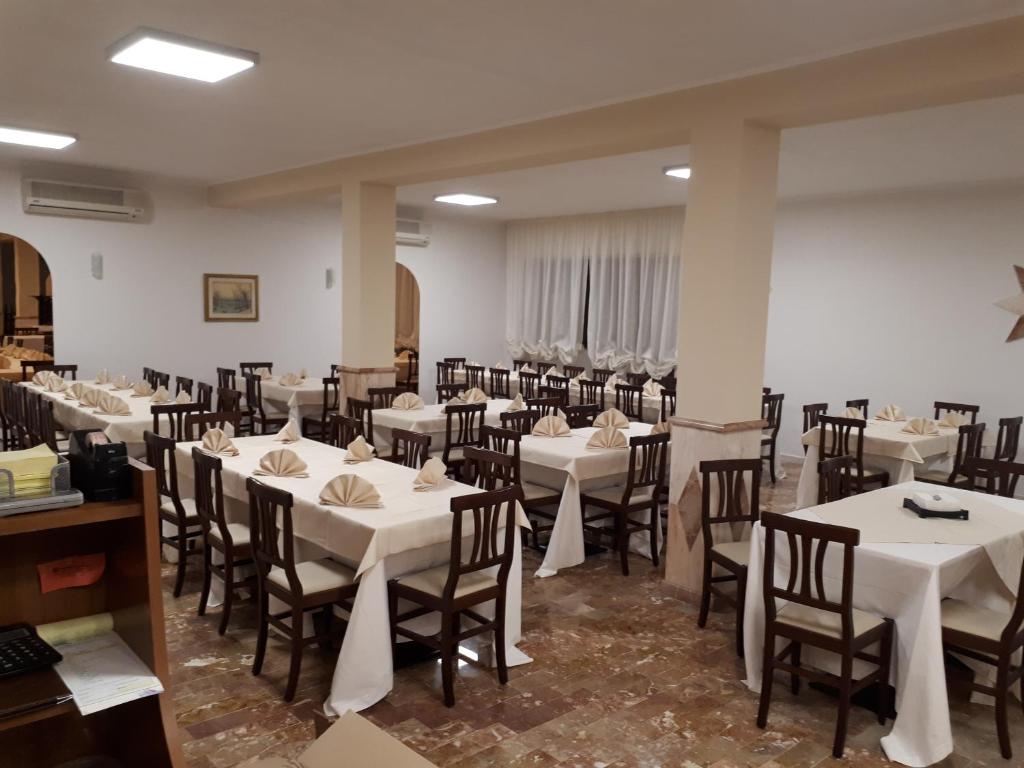 a dining room with white tables and chairs at La Collinetta in Montazzoli