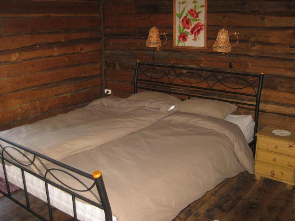 a bedroom with a bed in a log cabin at Aadu Holiday Farm in Suur-Rootsi