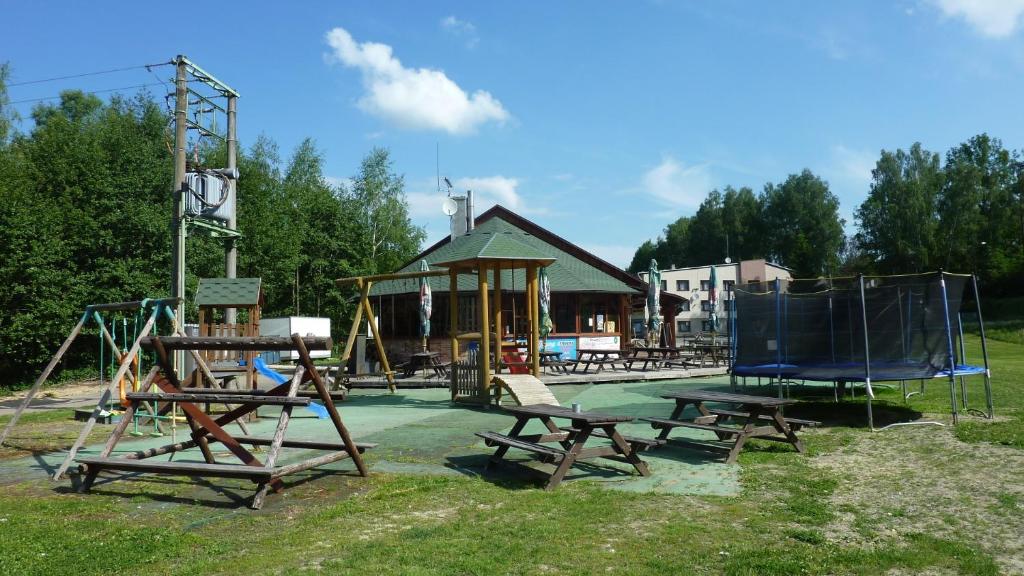 a playground with a picnic table and a swing set at Penzion Horalka in Hlinsko