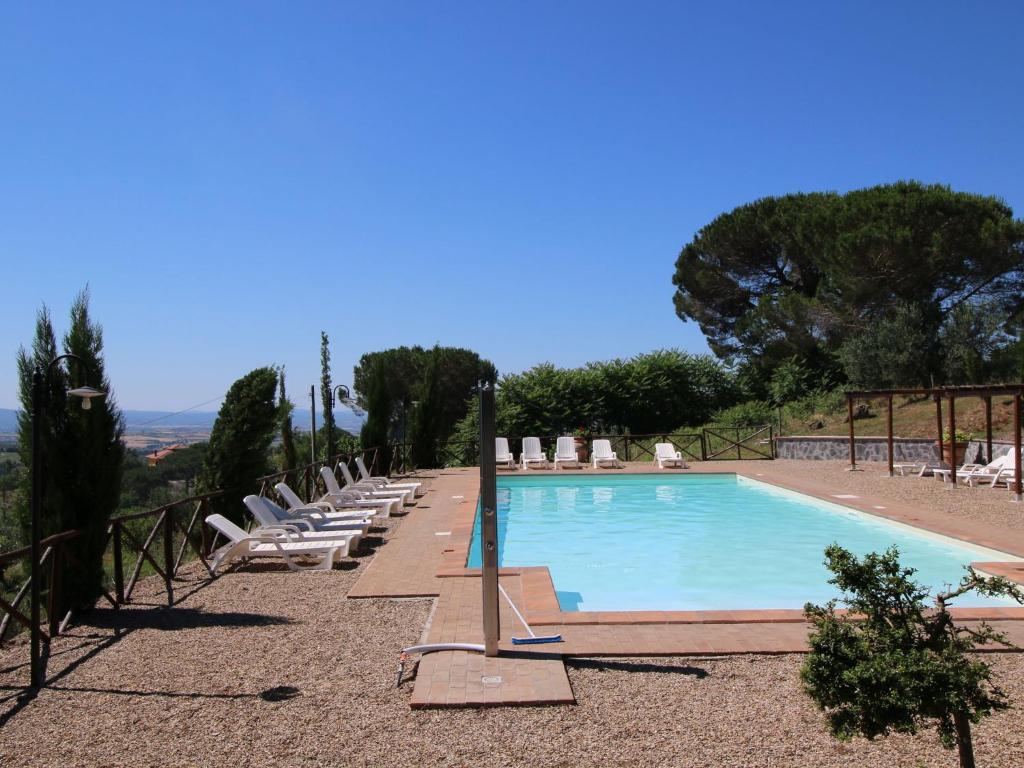 a large swimming pool with lounge chairs and a bunch at Farmhouse in Lazio with Lake Bolsena Views in Montefiascone