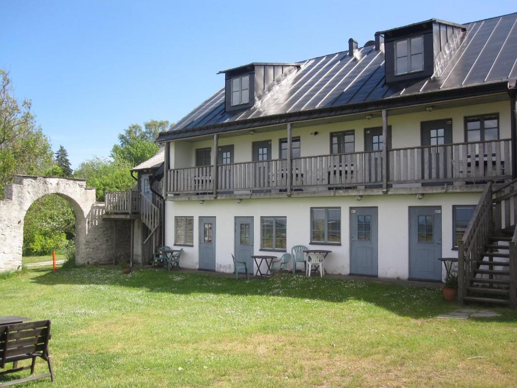 a large white house with a building with a balcony at Kalkpatronsgården Borgvik in Katthammarsvik