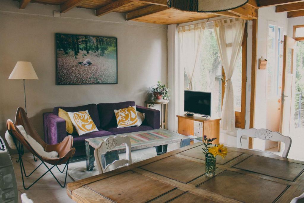 sala de estar con sofá y mesa en Casa Pocahullo en San Martín de los Andes