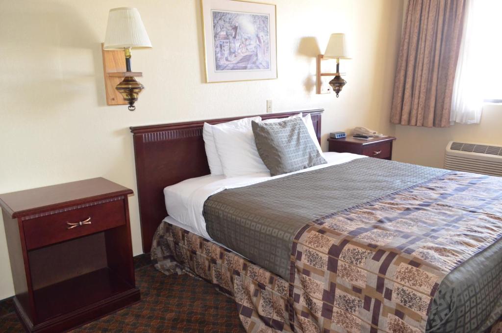 a hotel room with a bed and two night stands at National 9 Inn Wellington in Wellington