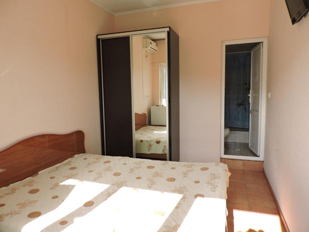 a bedroom with a bed and a mirror at Guest House Ostrov Sokrovishch in Loo