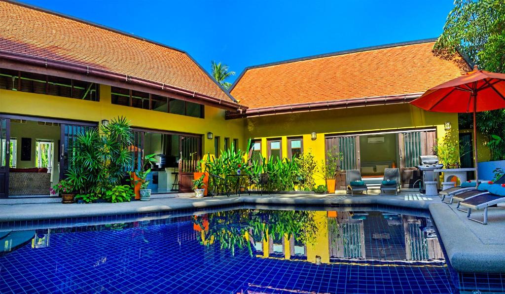 a house with a swimming pool in front of a house at Palm View Villa in Lamai