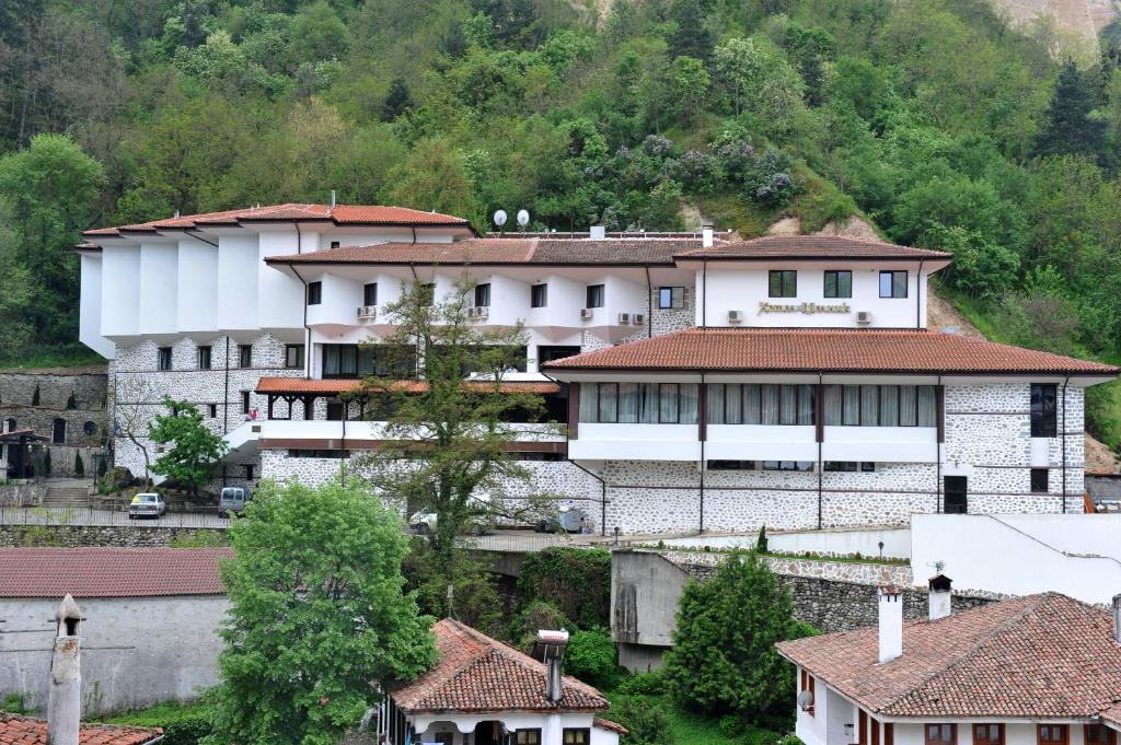 un groupe de bâtiments dans un village arboré dans l'établissement Hotel Melnik, à Melnik