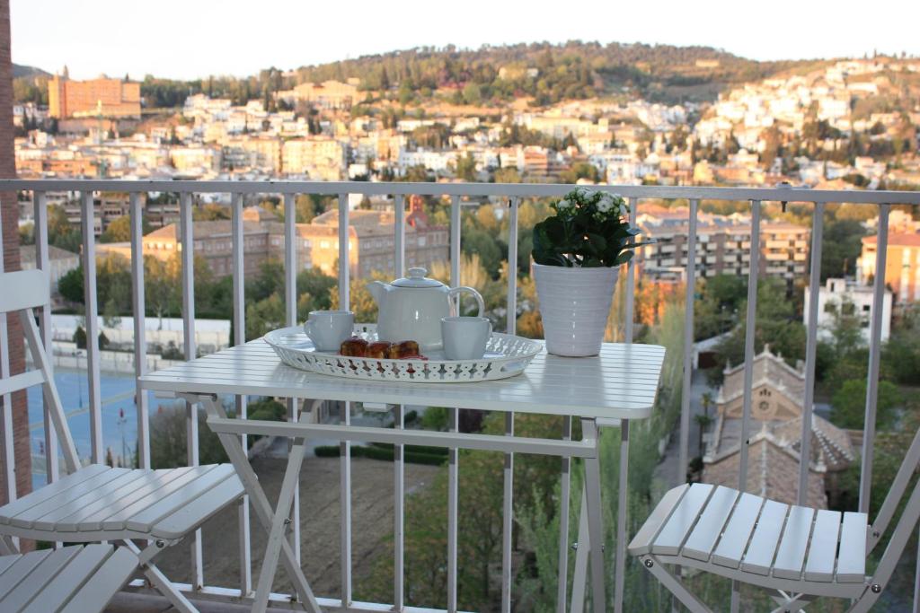 una mesa blanca con un plato de comida en el balcón en Apartamento Góngora, en Granada