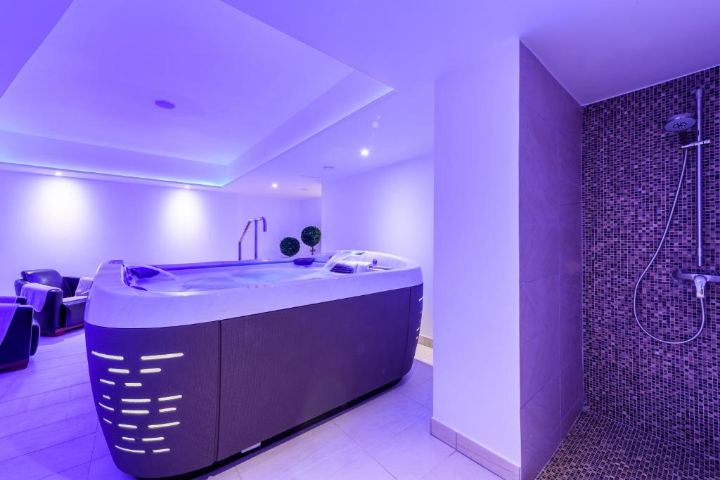 a bathroom with a large tub and a shower at Asterias Beach Hotel in Ayia Napa