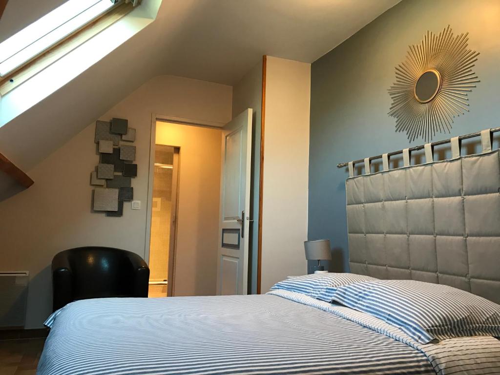 een slaapkamer met een bed en een zonnespiegel aan de muur bij La Grille Dorée in Amboise