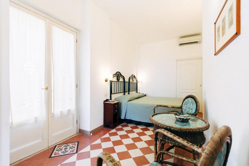a bedroom with a bed and a table and a chair at Villino Eleonora in Parghelia