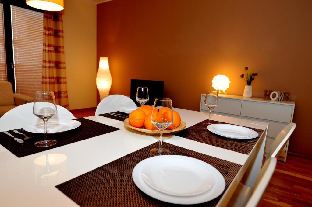einen Esstisch mit weißen Tellern und Weingläsern in der Unterkunft Apartament Czternastka in Świnoujście