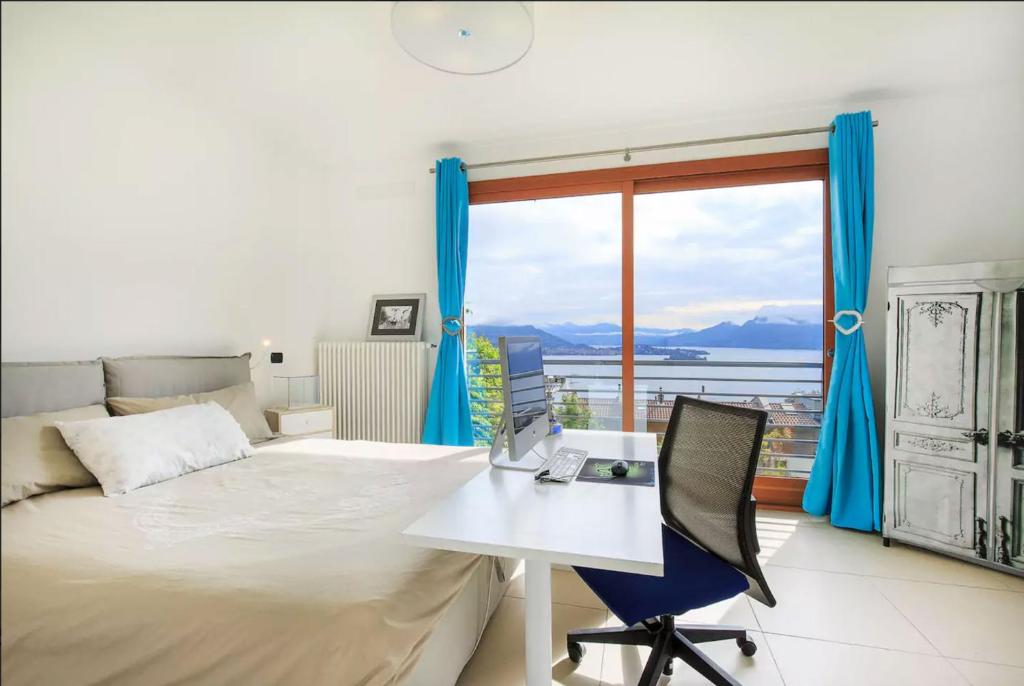 a bedroom with a bed and a desk and a window at Armonie del Lago in Baveno