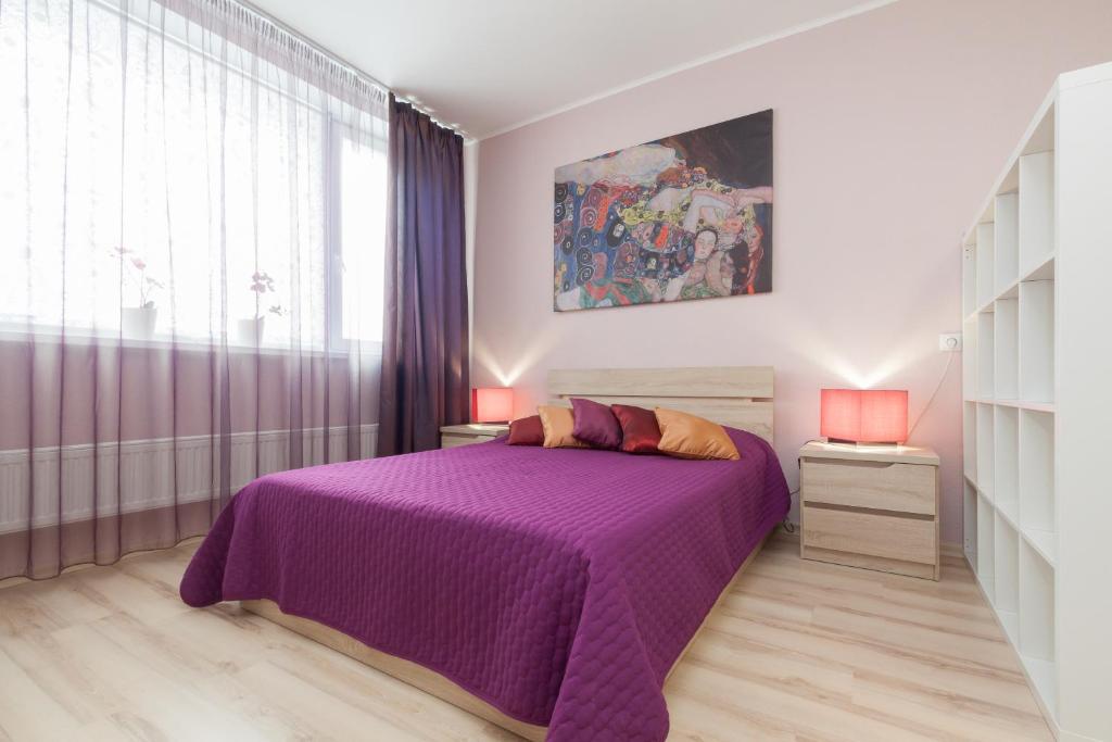 エカテリンブルクにあるАпартаменты ЭтажиДейли Центрのベッドルーム(紫色のベッド1台、窓付)