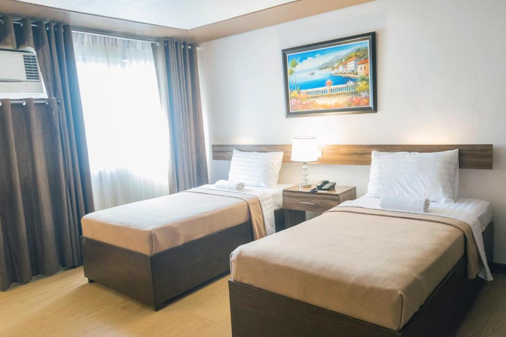 a hotel room with two beds and a window at Leope Hotel in Cebu City