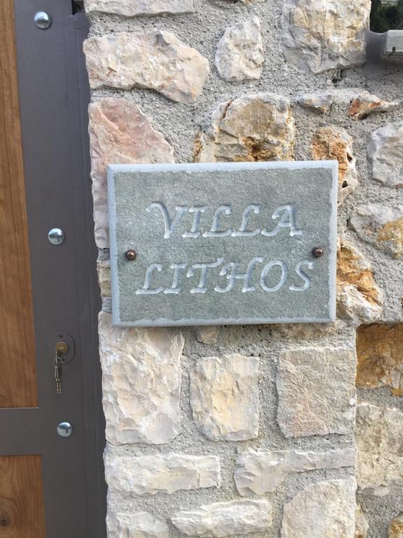 uma placa na lateral de um muro de pedra em Villa Lithos Parga em Parga