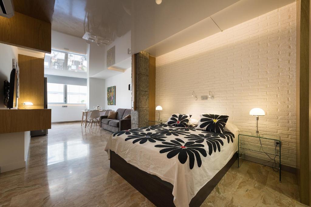 ラスパルマス・デ・グランカナリアにあるSuites Garden Loft Andy Warholのレンガの壁、大きなベッド付きのベッドルーム1室
