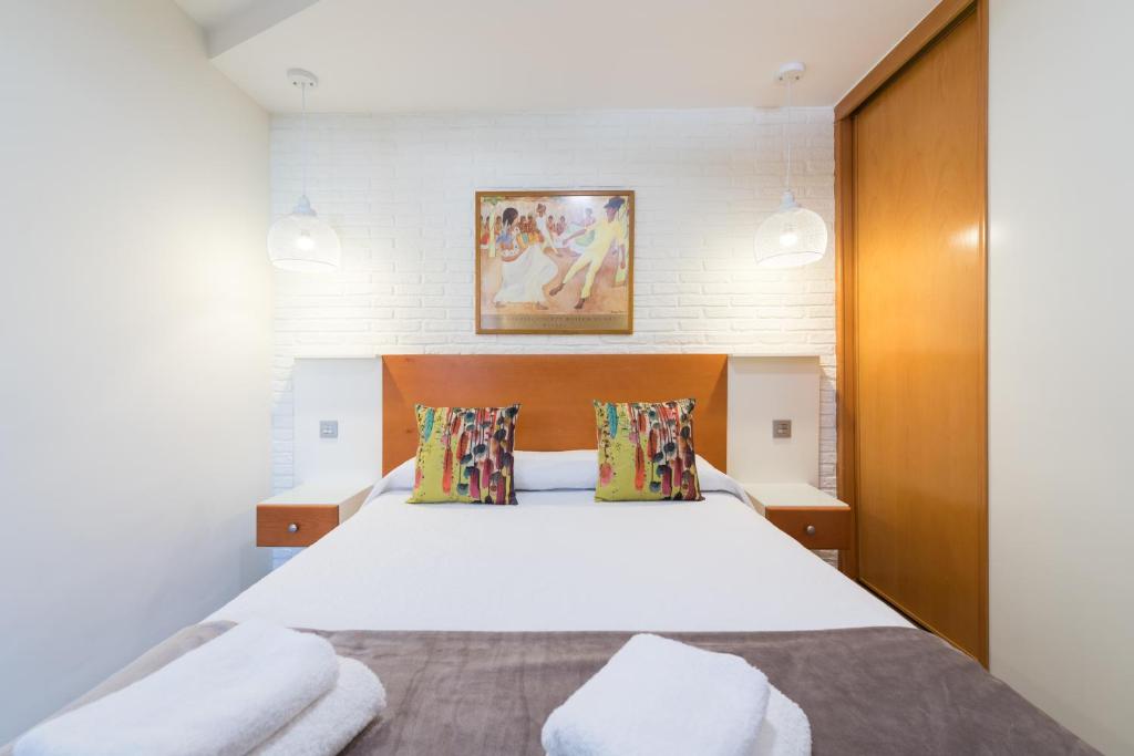 1 dormitorio con 1 cama blanca grande y 2 almohadas en Suites Garden Apartamento 42, en Las Palmas de Gran Canaria