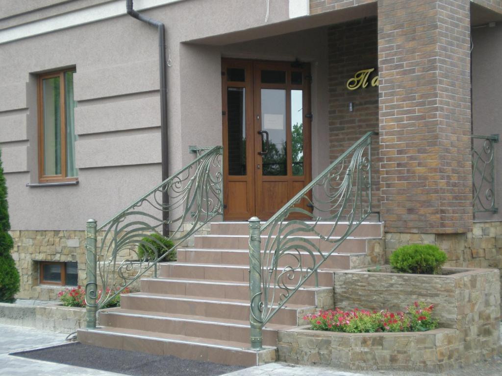 a front door of a house with stairs and flowers at Palada Hotel in Lviv