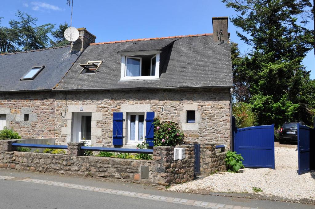 Quemper-GuézennecにあるGite Coriosolitesの青い扉のある古い石造りの家