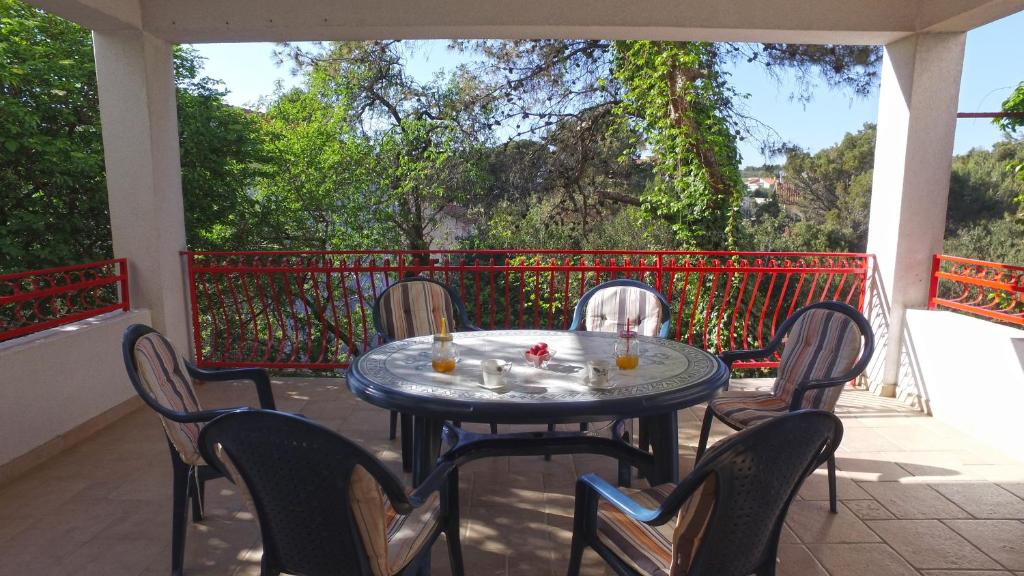 a table and chairs sitting on a porch with a table and chairs at Apartment Branko Brodarica in Brodarica