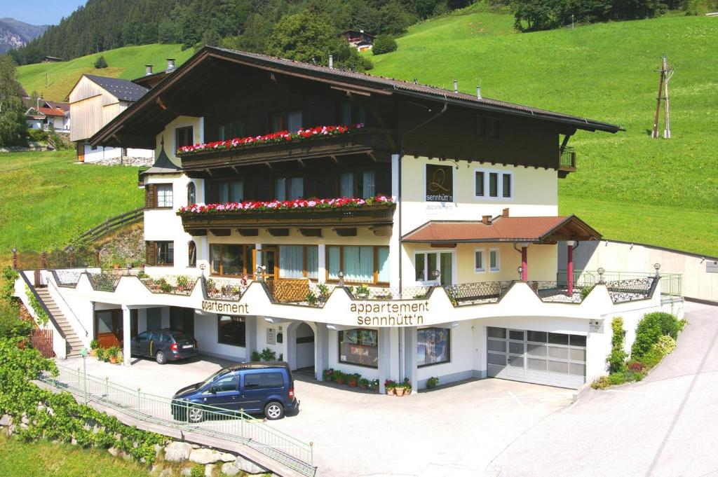 ein Haus mit einem davor geparkt in der Unterkunft Appartementhaus Sennhüttn in Finkenberg